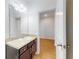 Bright bathroom features a granite vanity, framed mirror, wood plank flooring, and an open doorway at 534 Stowers Dr, New Smyrna Beach, FL 32168