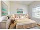 Bright bedroom featuring a stylish bed frame, soft pastel decor, and a large window for natural light at 534 Stowers Dr, New Smyrna Beach, FL 32168