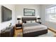 Modern bedroom with a sleek design, featuring dark wood furniture, soft gray bedding, and contemporary artwork at 534 Stowers Dr, New Smyrna Beach, FL 32168