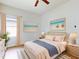 Cozy bedroom featuring soft pink bedding, beach-inspired wall art, and a calming ambiance enhanced by natural light at 534 Stowers Dr, New Smyrna Beach, FL 32168