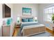 Comfortable bedroom featuring light and airy decor with bright blue accents, a decorative bedframe, and natural light at 534 Stowers Dr, New Smyrna Beach, FL 32168
