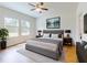 Comfortable bedroom features gray upholstered bed, modern lamps and side tables, with a view from bright windows at 534 Stowers Dr, New Smyrna Beach, FL 32168