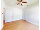 This bedroom features wood plank flooring, a ceiling fan, and white walls at 534 Stowers Dr, New Smyrna Beach, FL 32168
