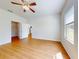 A bright bedroom boasts wood-look floors, a ceiling fan, and a walk-in closet for ample storage at 534 Stowers Dr, New Smyrna Beach, FL 32168