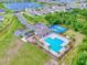 Aerial view of a community pool, tennis courts, playground, and surrounding residential area with a serene lake at 534 Stowers Dr, New Smyrna Beach, FL 32168
