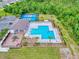 Aerial view showcasing a community pool, tennis courts, playground, and lush green surroundings at 534 Stowers Dr, New Smyrna Beach, FL 32168