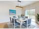 Bright dining room featuring a blue dining set, modern chandelier, and sliding glass doors at 534 Stowers Dr, New Smyrna Beach, FL 32168