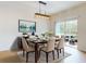 Bright dining room featuring a modern chandelier, wood dining set, and sliding glass doors at 534 Stowers Dr, New Smyrna Beach, FL 32168