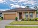 Charming single-story home featuring a well-manicured lawn, brown roof, and inviting entryway at 534 Stowers Dr, New Smyrna Beach, FL 32168