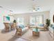 Inviting living room with white wicker furniture, plush blue pillows and a glass coffee table atop neutral rug at 534 Stowers Dr, New Smyrna Beach, FL 32168