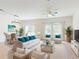 Bright living room with wicker furniture, plush teal pillows, glass coffee table, creating inviting gathering space at 534 Stowers Dr, New Smyrna Beach, FL 32168