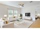 Bright living room showcasing stylish white sofas, and a ceiling fan with modern furnishings at 534 Stowers Dr, New Smyrna Beach, FL 32168