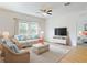 Bright living room showcasing stylish wicker furniture, white sofas, and a ceiling fan at 534 Stowers Dr, New Smyrna Beach, FL 32168