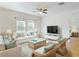 Bright living room showcasing stylish wicker furniture, white sofas, and a ceiling fan at 534 Stowers Dr, New Smyrna Beach, FL 32168