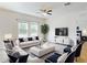 Bright living room showcasing stylish white sofas and chairs, modern furnishings, and a ceiling fan at 534 Stowers Dr, New Smyrna Beach, FL 32168