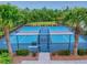 View of community pickleball courts framed by palm trees and landscaping, enclosed by a black fence at 534 Stowers Dr, New Smyrna Beach, FL 32168