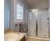 Well-lit bathroom with a shower and glass door, a vanity with sink, and plantation shutters at 535 Coral Trace Blvd, Edgewater, FL 32132