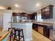 Modern kitchen boasts stainless steel appliances, dark wood cabinets, and a breakfast bar at 535 Coral Trace Blvd, Edgewater, FL 32132