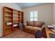 Home office featuring a comfortable sofa, built-in bookcase, and window with plantation shutters at 535 Coral Trace Blvd, Edgewater, FL 32132