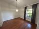 Bright dining room features wood floors, chair rail, window with curtains, and elegant light fixture at 547 Cleo Ln, Deltona, FL 32738