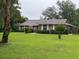 Well-maintained brick home featuring manicured landscaping and a lush green lawn at 547 Cleo Ln, Deltona, FL 32738