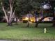 Exterior view of a brick home with mature trees in the front yard at twilight at 547 Cleo Ln, Deltona, FL 32738