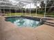 Inviting pool area with screened enclosure and waterfall feature, surrounded by well-maintained landscaping at 547 Cleo Ln, Deltona, FL 32738