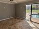 Enclosed sun room featuring stone floors, a ceiling fan, and sliding glass doors to the pool area at 547 Cleo Ln, Deltona, FL 32738