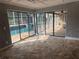 Enclosed sun room featuring stone floors, a ceiling fan, and sliding glass doors to the pool area at 547 Cleo Ln, Deltona, FL 32738