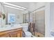 Bathroom featuring a tiled shower with glass doors, toilet, single sink vanity and large mirror at 6320 S Atlantic Ave, New Smyrna Beach, FL 32169
