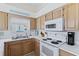Bright kitchen featuring white appliances, wood cabinets, and durable countertops at 6320 S Atlantic Ave, New Smyrna Beach, FL 32169