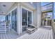 Relaxing porch with access to stairs and comfortable seating looking into the living area at 6320 S Atlantic Ave, New Smyrna Beach, FL 32169