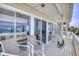 Inviting covered porch with comfortable seating offers peeks into the open-concept kitchen at 6320 S Atlantic Ave, New Smyrna Beach, FL 32169