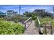 Private walkway leading to a pristine beach, surrounded by lush vegetation, enhancing the property's appeal at 6320 S Atlantic Ave, New Smyrna Beach, FL 32169