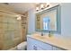 Bathroom featuring a tiled shower with glass doors, a vanity with a sink and a decorative mirror at 6871 S Atlantic Ave., New Smyrna Beach, FL 32169