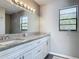Bathroom featuring a long mirror and dual sinks with granite countertops at 7 Heather Ln, Ormond Beach, FL 32174