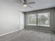 Bright, carpeted bedroom featuring a ceiling fan and a large window with a peaceful view at 7 Heather Ln, Ormond Beach, FL 32174
