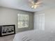 Cozy bedroom featuring a ceiling fan, and a large window offering a serene view of the outdoors at 7 Heather Ln, Ormond Beach, FL 32174