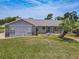 A well-maintained home with stone accents, a walkway, and lush landscaping offers great curb appeal at 7 Heather Ln, Ormond Beach, FL 32174