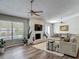 Bright living room featuring a fireplace, large windows and wood-look flooring at 7 Heather Ln, Ormond Beach, FL 32174