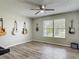 The living room features vinyl floors, a ceiling fan, large windows, and neutral-colored walls at 7 Heather Ln, Ormond Beach, FL 32174