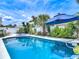 Inviting pool surrounded by tropical landscaping and stylish patio furniture under a sunny sky at 7 Heather Ln, Ormond Beach, FL 32174
