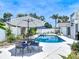 Poolside patio area featuring an umbrella, table and chairs, and beautiful landscaping at 7 Heather Ln, Ormond Beach, FL 32174