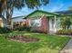 Beautifully landscaped home with a lush green lawn, colorful flowers, and a charming front entryway at 708 Egret Ct, Edgewater, FL 32141