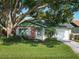 Charming home with green lawn and landscaping featuring a mature shade tree at 708 Egret Ct, Edgewater, FL 32141