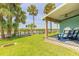 Relaxing covered porch overlooking a tranquil waterfront view with palm trees at 76 Heather Point Ct, New Smyrna Beach, FL 32169
