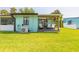 Green backyard view with a covered deck and blue accents providing a serene retreat at 76 Heather Point Ct, New Smyrna Beach, FL 32169