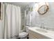 Bright bathroom with a new sink, a mirror surrounded with rope and a shower with white curtains at 76 Heather Point Ct, New Smyrna Beach, FL 32169