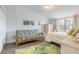 Bright bedroom featuring a futon and a decorative palm leaf rug for a beachy vibe at 76 Heather Point Ct, New Smyrna Beach, FL 32169