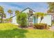 Charming aqua-colored villa with well-maintained landscaping and lush green lawn at 76 Heather Point Ct, New Smyrna Beach, FL 32169